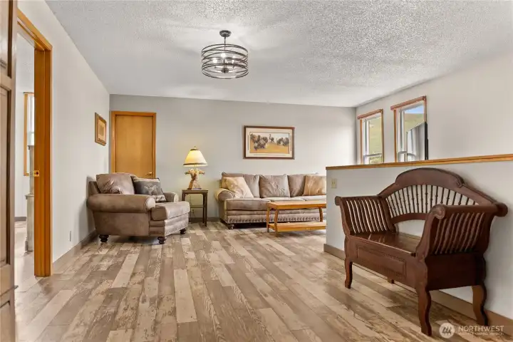 Second-story living area at the top of the stairs, offering a comfortable bonus space, TV room and additional storage tucked neatly behind the door.