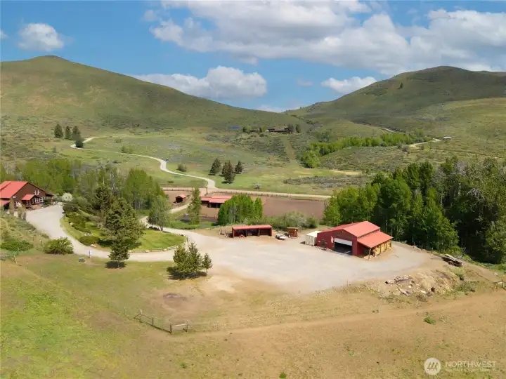 Native landscape with a wild aspen grove and a seasonal creek meandering through, complemented by wood rail fencing and multiple fields and paddocks for easy rotation and seasonal use—simple, functional, and true to the Methow Valley lifestyle.
