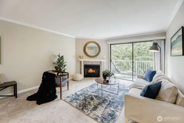 Cozy and bright living room with wood burning fireplace and deck access.