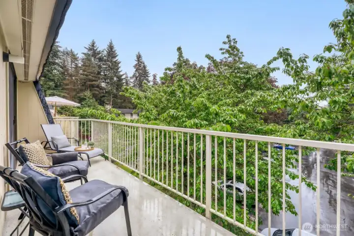 Secure top floor living with treed view and partial parking lot view.