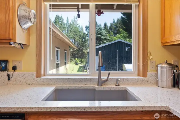 Kitchen sink looks to the backyard. fully fenced. Propane cooktop.