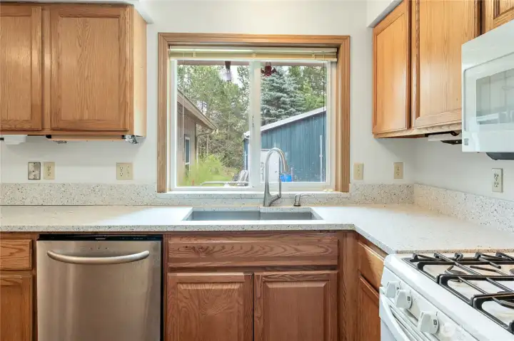 Kitchen sink looks to the backyard. fully fenced. Propane cooktop.