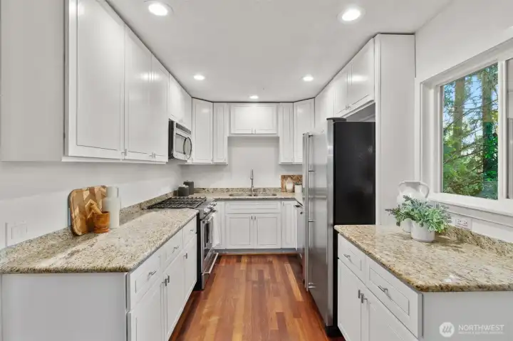 Updated kitchen with stainless steel appliances, granite countertops and abundant workspaces.