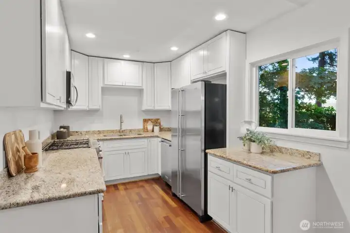 Crisp white cabinetry and a picture window create a bright and functional kitchen.