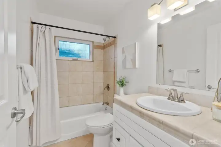 Full-sized bath featuring timeless tile finishes and abundant natural light.