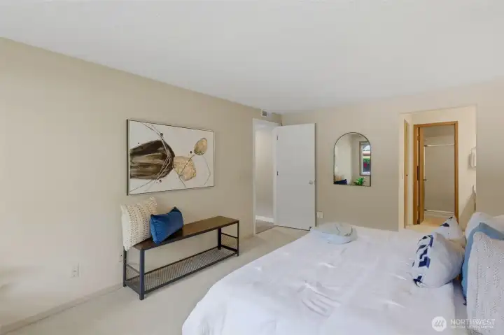 The primary vanity is open to the bedroom with a door separating it from the shower and toilet room.