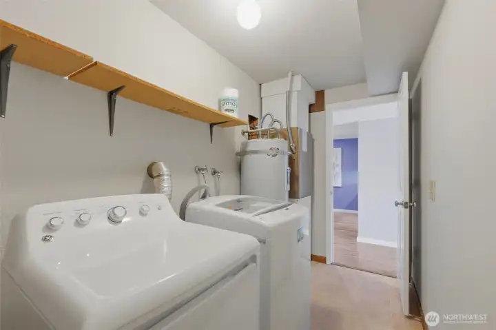 A large utility and storage room sits across the hallway from the kitchen. There’s about 5ft by 5ft of storage behind the photographer. The water heater was replaced in 2020, and the furnace was recently serviced.