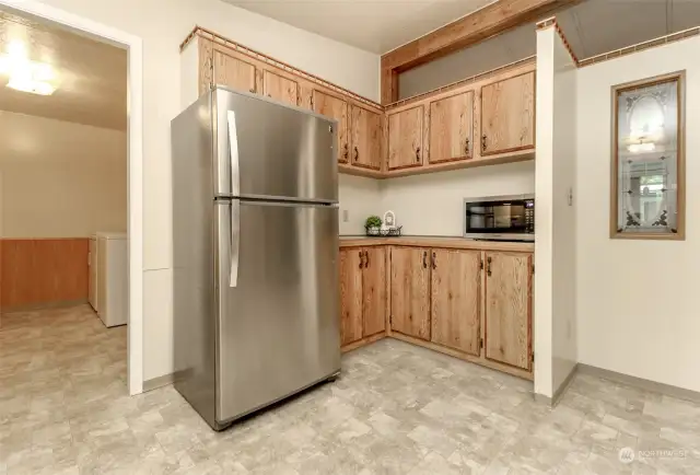 Corner of the kitchen with extra cabinets, microwave and access to the utility room and back door.