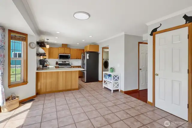 Kitchen and dining area with a small look into the utility room located off the kitchen.  1/2 bath is located to the right as you head down the hall leading to the main entrance of home.