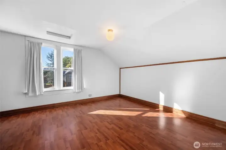 Primary bedroom with windows overlooking the street.