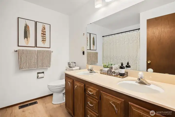 Off the main hallway, this full bathroom features double sinks & ample storage space.