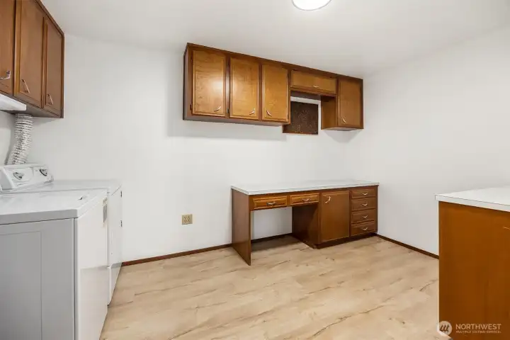 The laundry room features a handy desk area and ample storage.
