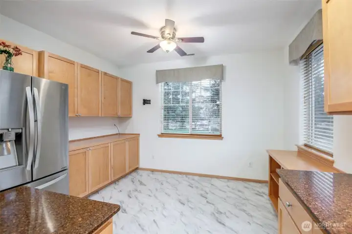Another view of this kitchen looking from the open air breakfast bar into the kitchen eat in area with custom built-in cabinets for extra storage and full functionality.