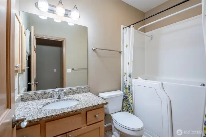 The hall bath features an accessible shower/bath system.