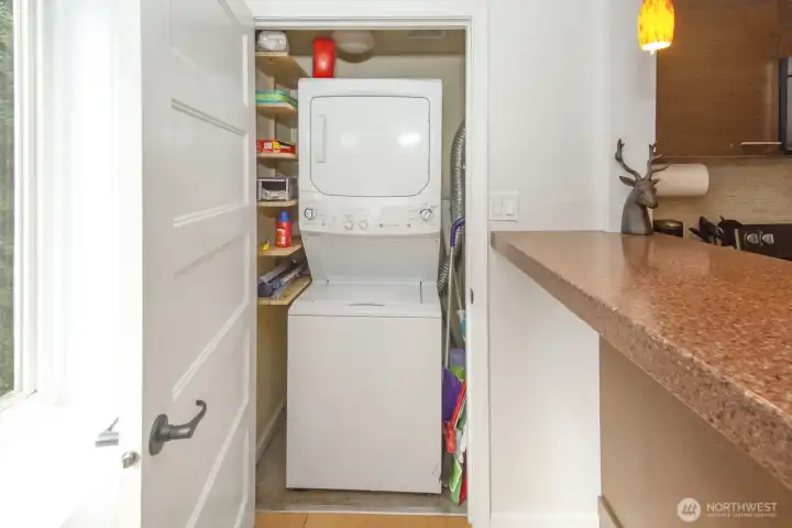 In-unit washer and dryer inside closet next to kitchen.