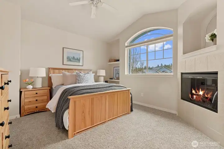 Primary bedroom offers gas fireplace, vaulted ceilings and oversized windows