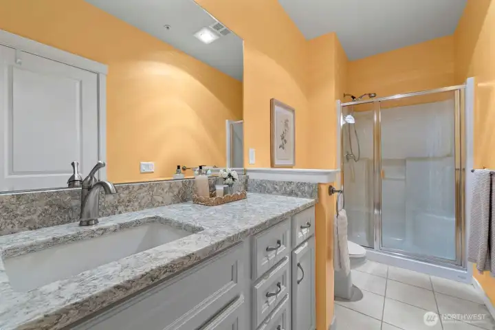 Second bathroom with solid wood cabinetry and slab countertops