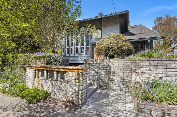 The owners of many years added a mid-century flair to this home with tall vertical windows, skylights and extensive brickwork embracing the front yard.