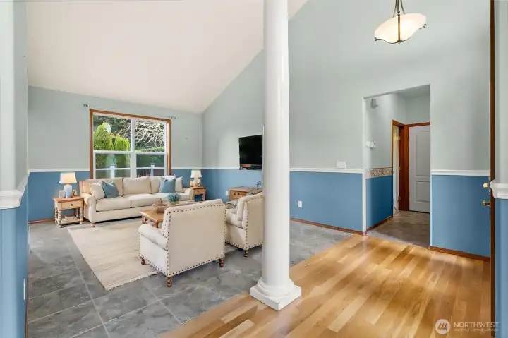 VIRTUALLY STAGED formal living room with vaulted ceilings.  Bedroom wing to the right, kitchen & family room to the left.