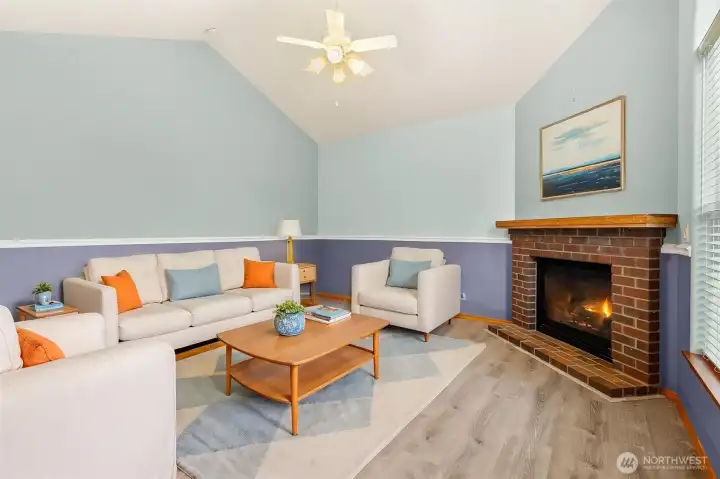 VIRTUALLY STAGED family room with overhead fan and cozy fireplace.