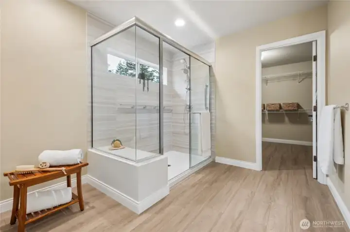 Luxurious primary bath features a walk in shower, double sinks and an expansive walk in closet