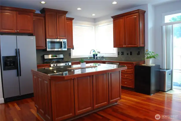 Real Brazilian cherry hardwood floors on the main level. The kitchen features granite counter tops, stainless steel appliances, gas range, butler's pantry, breakfast/dining area, and custom cabinetry accented with crown molding.