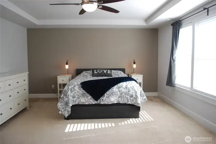 Large primary suite with ceiling fan and coffered ceiling.
