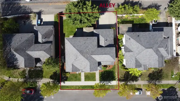 Aerial view of impressive exterior with mature landscaping, washed aggregate walkways, designer paint, covered front entry, and rear patio with cover.