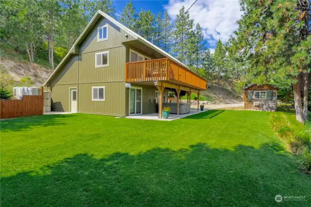 Exterior view of home w/ grassy landscaped yard.