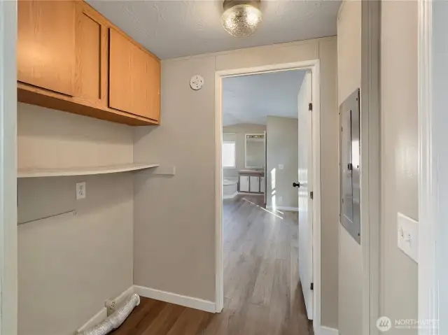 Laundry area with cabinets tucked away in the hall.