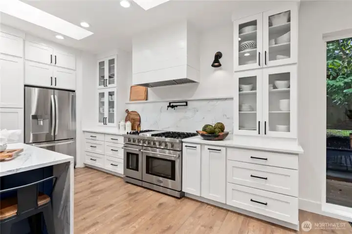 View of wall of cabinets perfect for storage and professional gas range perfect for gourmet cooking!