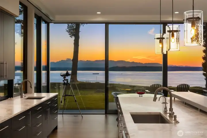 Twilight views transform this designer chef’s kitchen into a dramatic waterfront showpiece overlooking Puget Sound and the Olympic Mountains in coveted Woodway, WA.