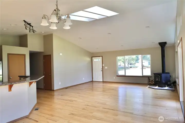 Open living room with skylights This living space feels bright, airy, and peaceful, with vaulted ceilings, skylights, hardwood floors, and a cozy wood stove that makes you want to stay awhile.