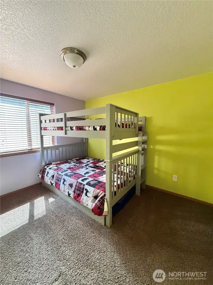 Bunk room / guest bedroom  A cheerful bedroom ready for guests, kids, or weekend visitors — ideal for a recreational getaway where everyone has a place to land after a day of skiing, fishing, flying, or exploring.