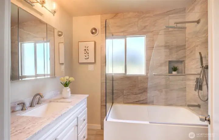 Newly renovated bathroom with tile surround and waterfall shower