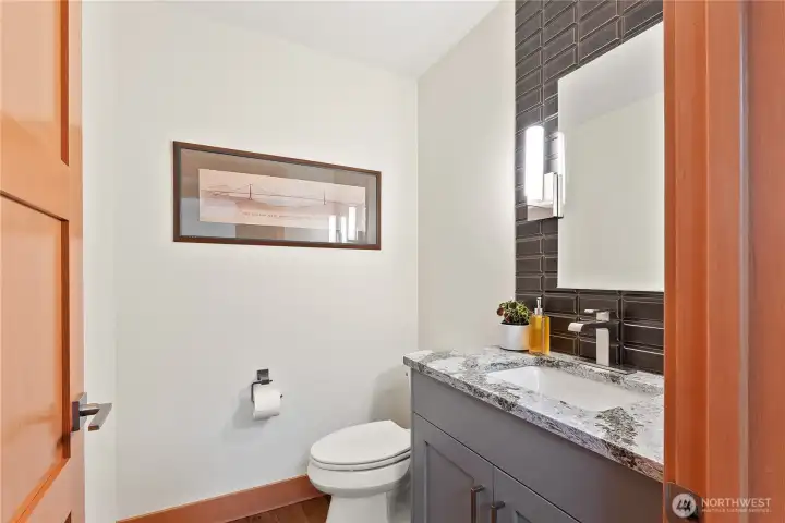 Guest bathroom on the main level with custom tile work and quartz countertops