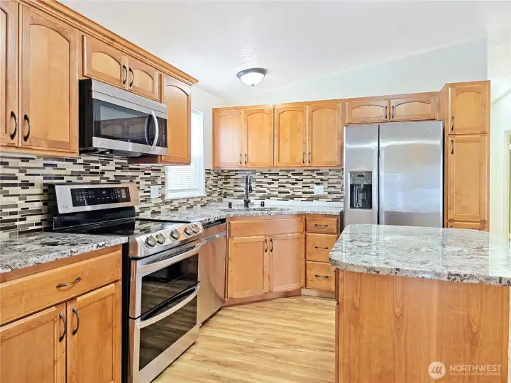 Quality stainless steel appliances include a smooth-top double oven range, side-by-side refrigerator, dishwasher, and over-the-range microwave.