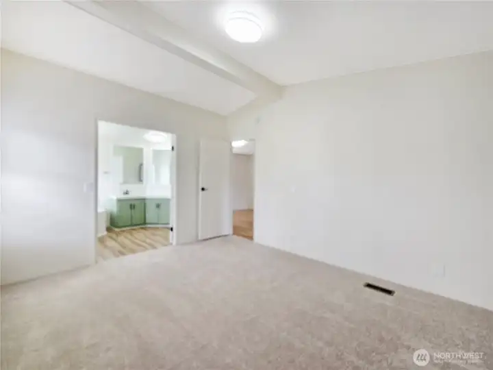 Double-door entry connects the primary suite to the luxurious five-piece bathroom.