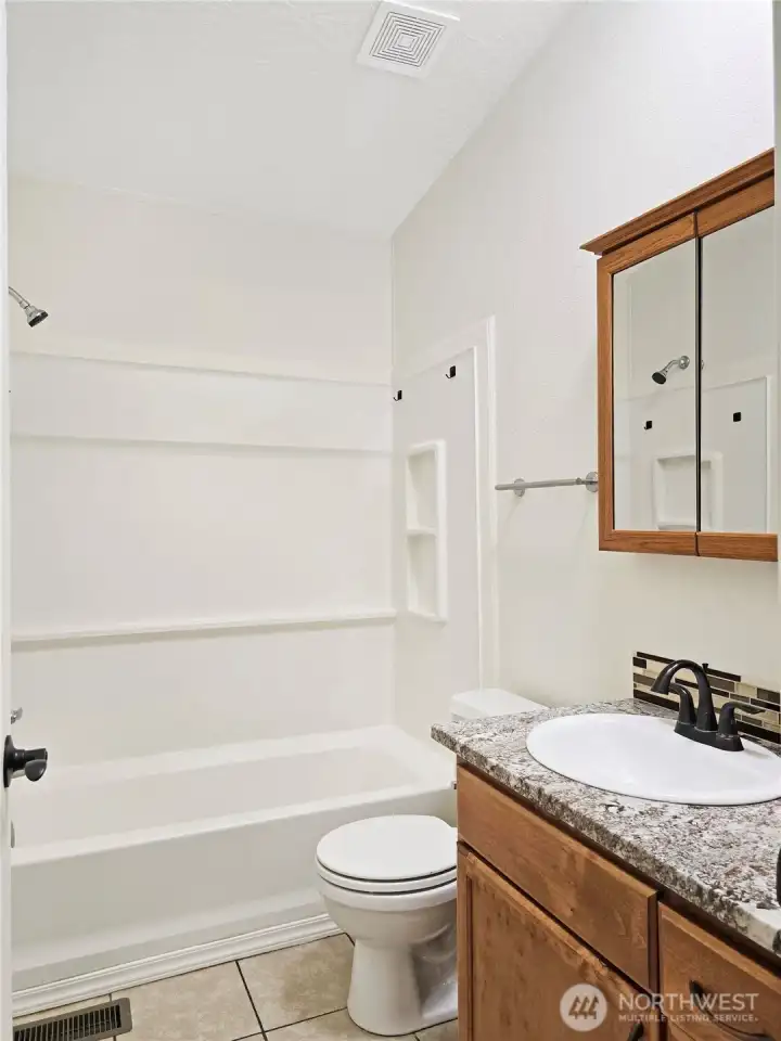 Hall bath features a beautiful granite countertop too.