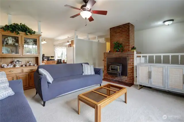 This spacious living room boasts a cozy wood stove, perfect for chilly evenings and creating a warm, inviting atmosphere