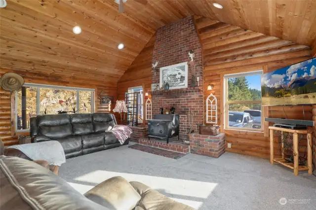 Great room with cozy brick surround woodstove and vaulted ceilings