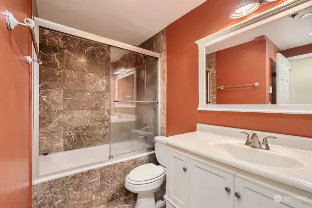 Spacious central bathroom. Beautiful marble tiling surround jetted tub. Keep your toes warm with the heated stone tile.