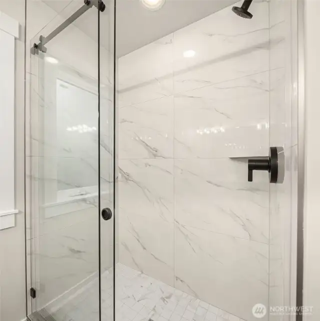 Luxurious marble-accented shower.