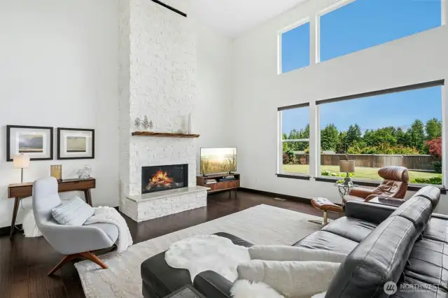 Magnificent 2 story living room with soaring cathedral ceilings & dramatic limestone fireplace
