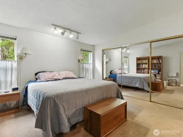 The spacious primary bedroom is a true retreat, offering room to unwind in comfort and style. It features not only a custom and generous walk-in closet but also an additional large closet.