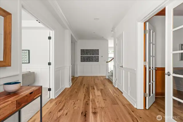 Impressive sense of arrival with wide entry and hallway, beautiful engineered hickory wood flooring, and wainscoting