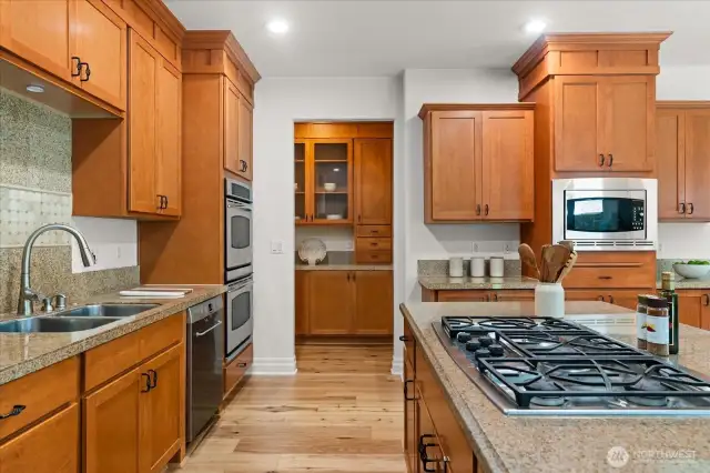 Large island with granite countertops and five-burner gas cooktop