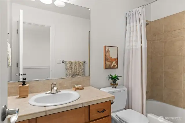 Main bathroom conveniently located next to secondary bedroom, offers tub with tile surround