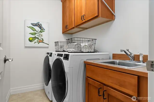 Conveniently located upstairs laundry room with deep sink and storage cabinets