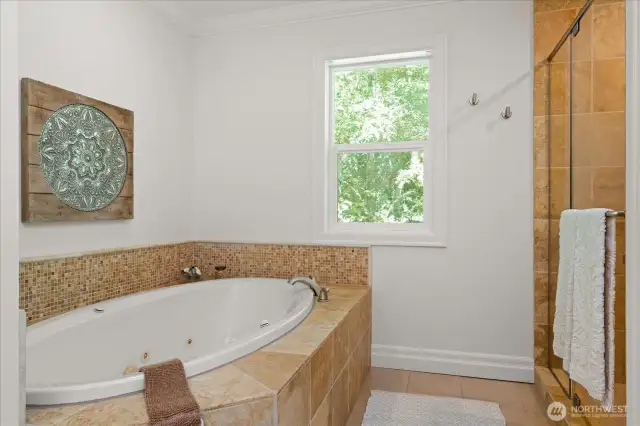 A feeling of luxury in the primary bath with jeffed soaking tub, and large tiled walk-in shower